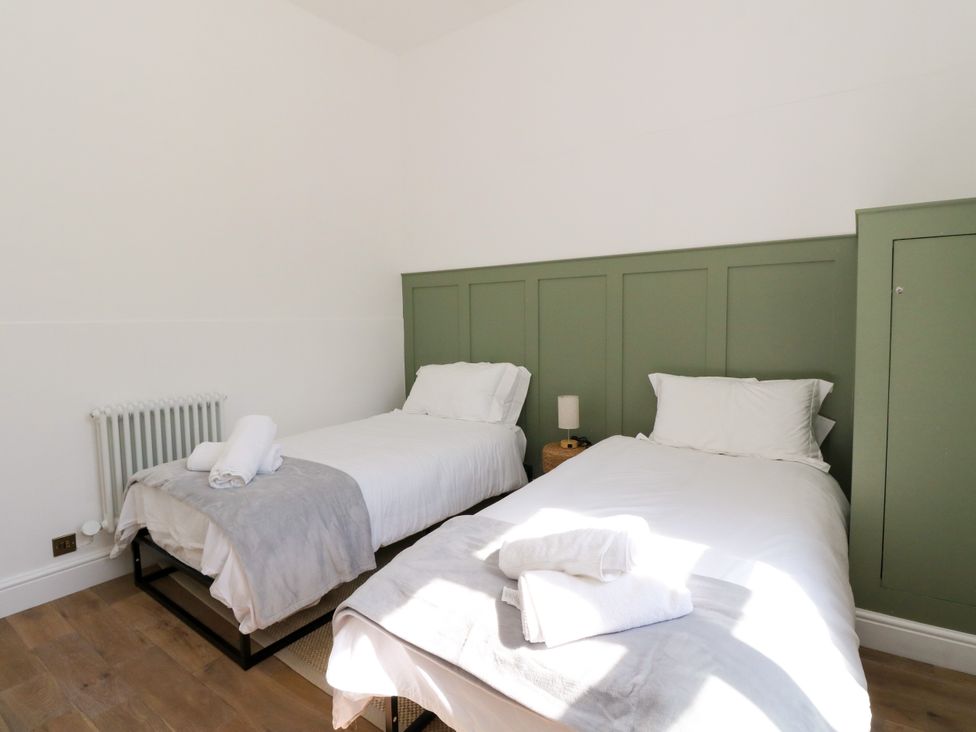 A bedroom with two beds and a radiator at Flat 1 