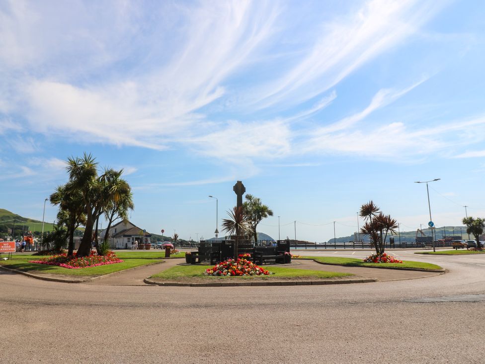 A roundabout with palm trees and flower beds at Flat 1