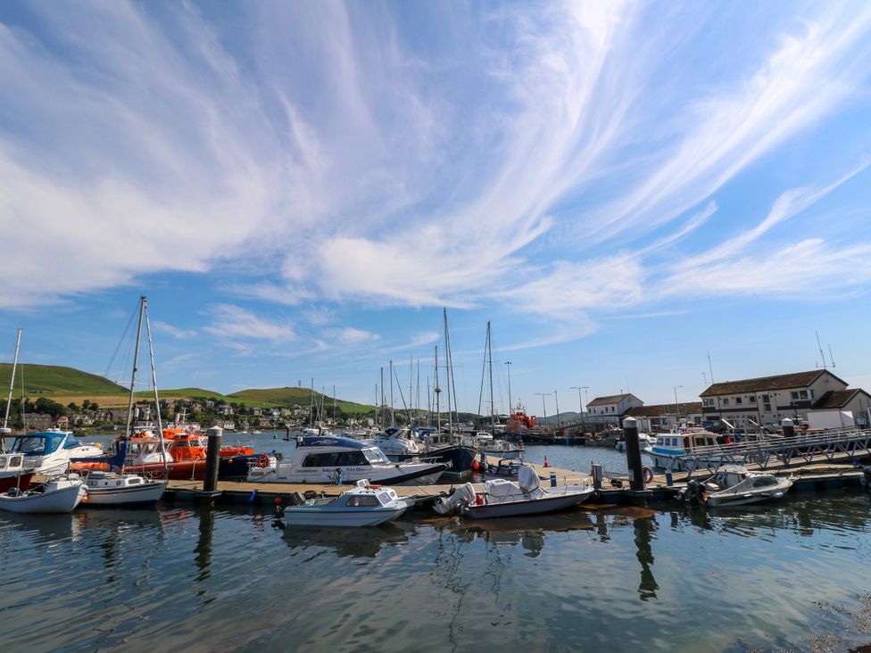 A marina with boats docked and buildings at Flat 1 