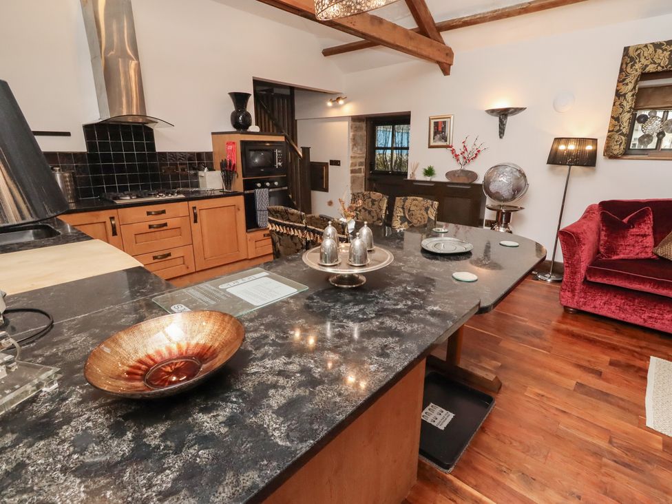 A kitchen with a stove and dining table at The Opulent in Hexham
