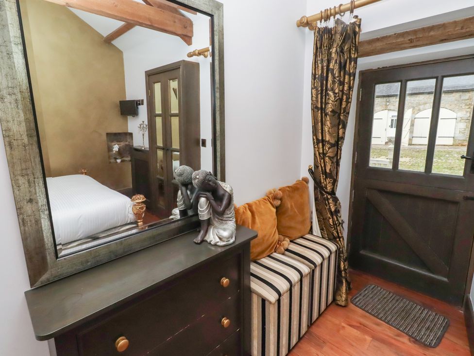 A bedroom with a mirror and dresser at The Opulent in Hexham