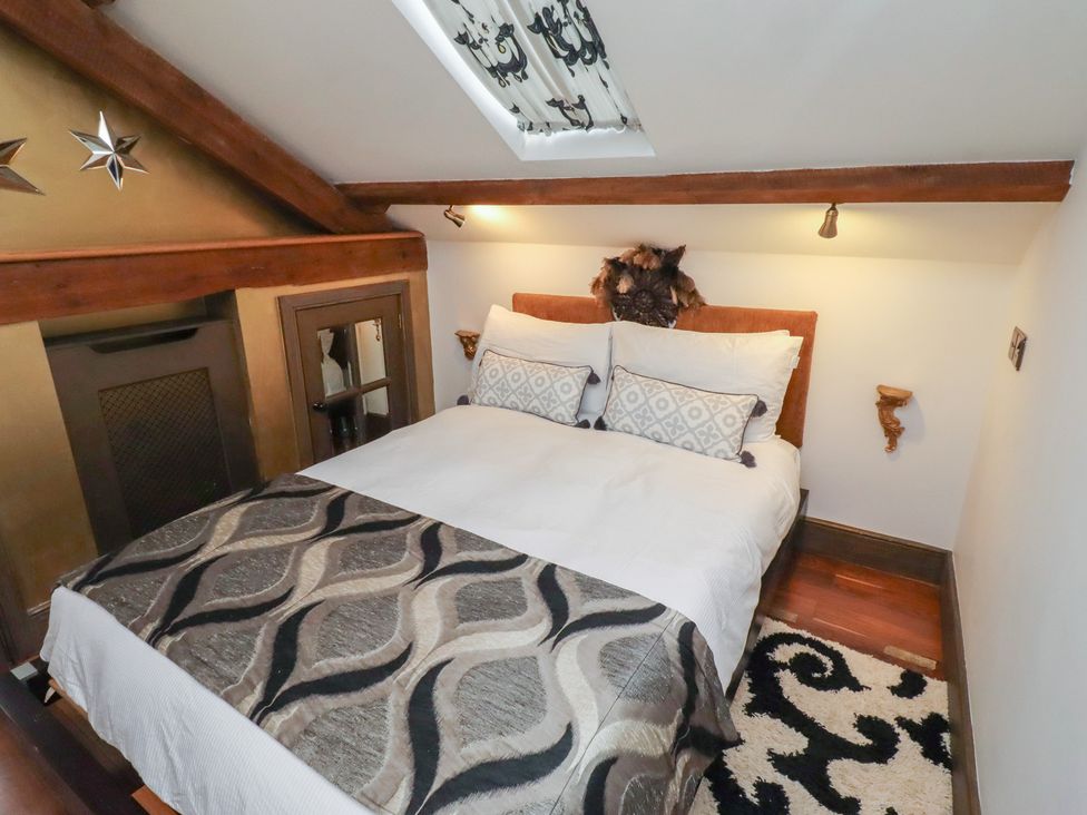 A bedroom with a bed and a fireplace at The Opulent in Hexham