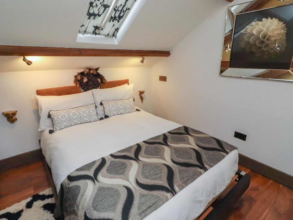 A bedroom with a bed and artwork on the wall at The Opulent in Hexham