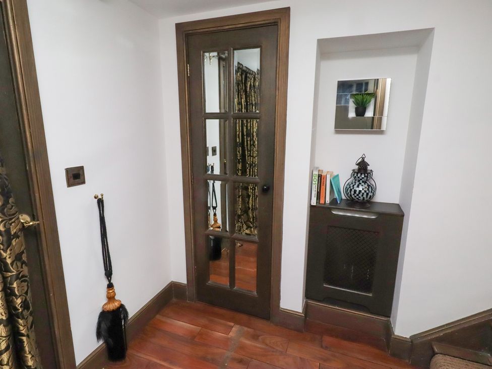 A hallway with a door and a cabinet at The Opulent in Hexham