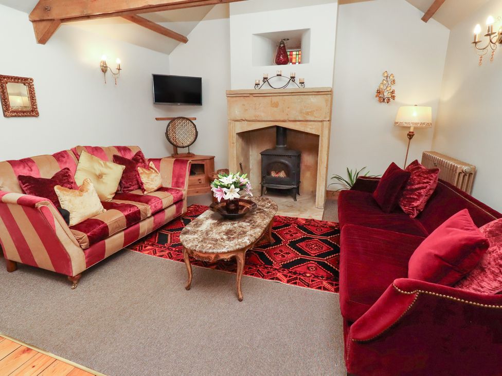 A living room with a fireplace and sofa at The Classic in Hexham