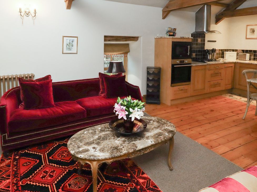 A living room with a sofa and kitchenette at The Classic in Hexham