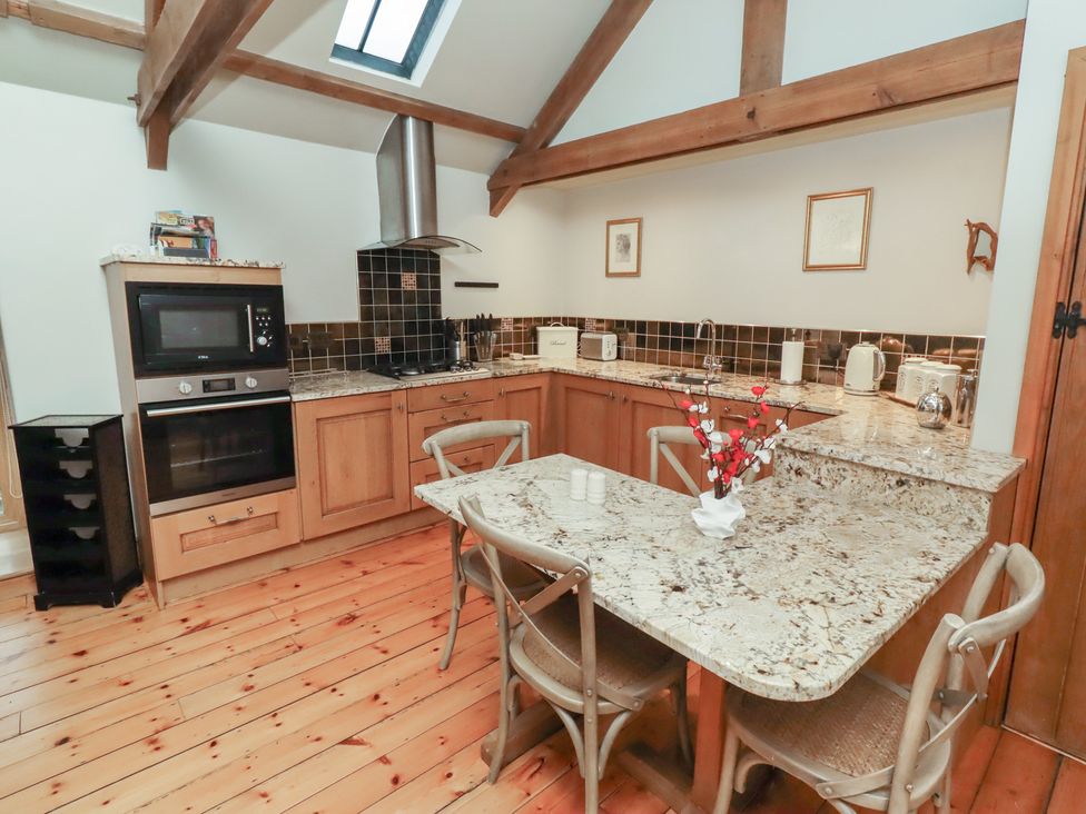 A kitchen with cabinets and a dining table at The Classic in Hexham