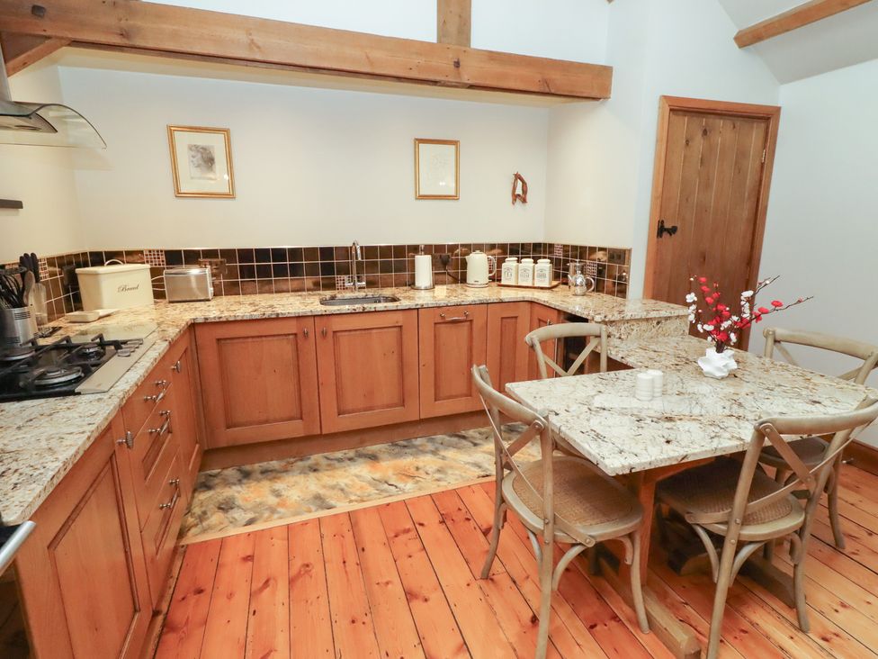 A kitchen with wooden cabinets and a table at The Classic in Hexham