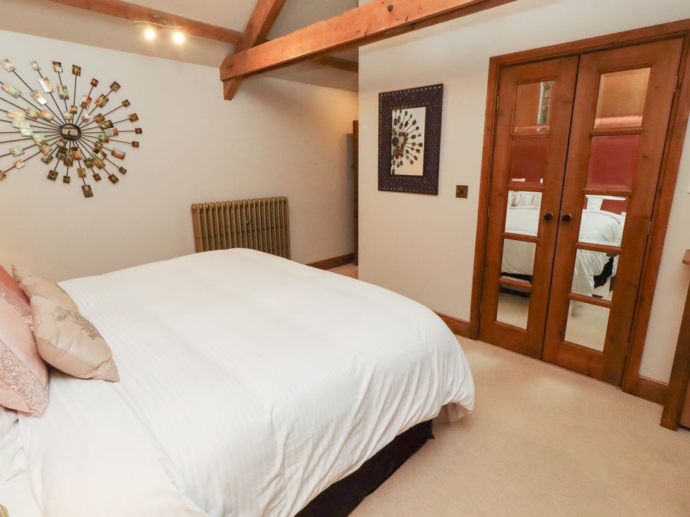 A bedroom with a bed and mirror at The Classic in Hexham