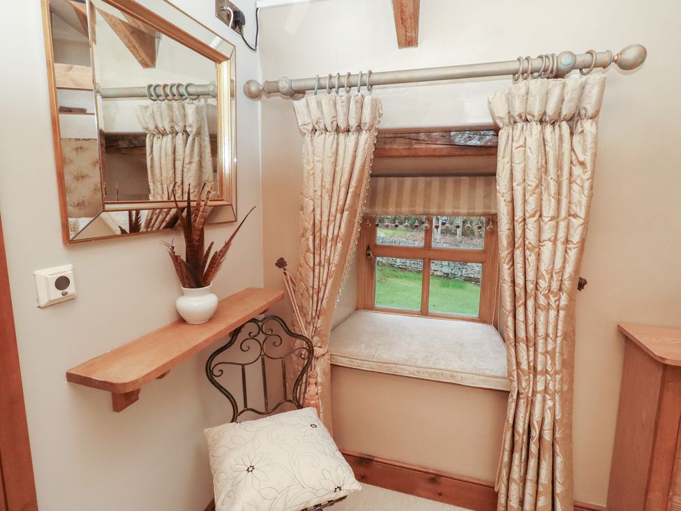 A sitting room with a mirror and chair at The Classic in Hexham