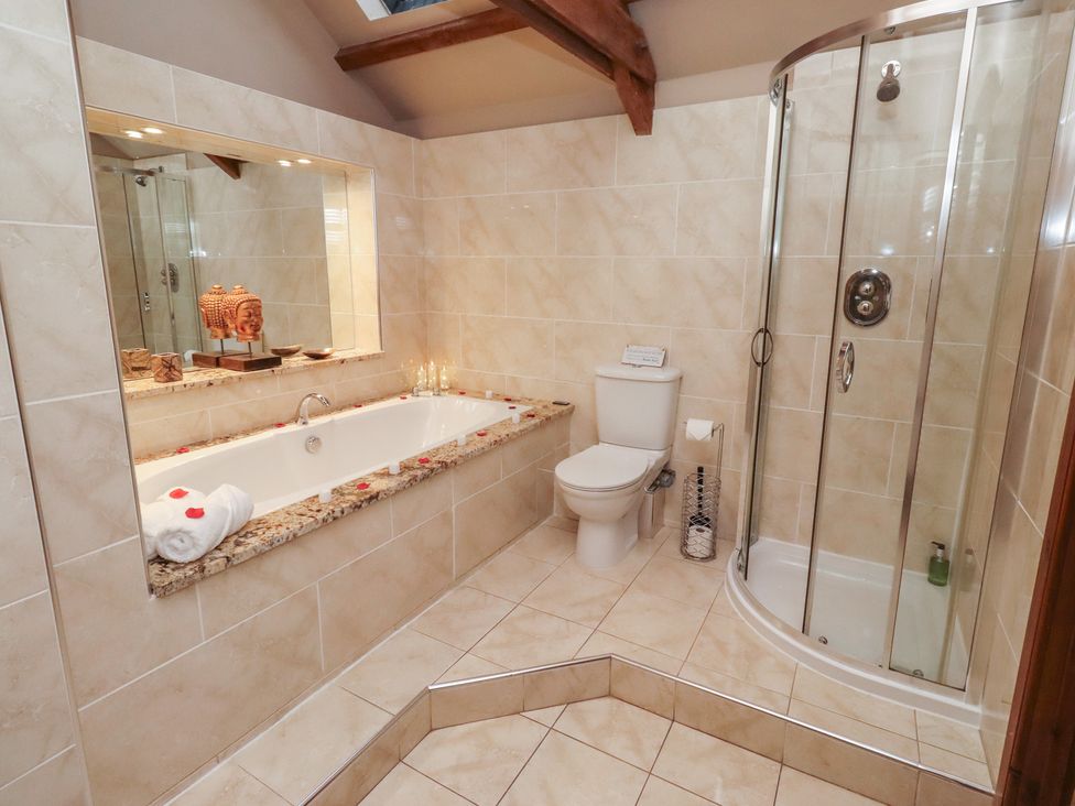 A bathroom with a bathtub, shower, toilet, and sink at The Classic in Hexham