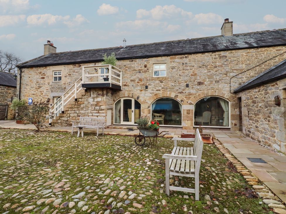 A stone building with stairs and benches in a garden at The Classic in Hexham