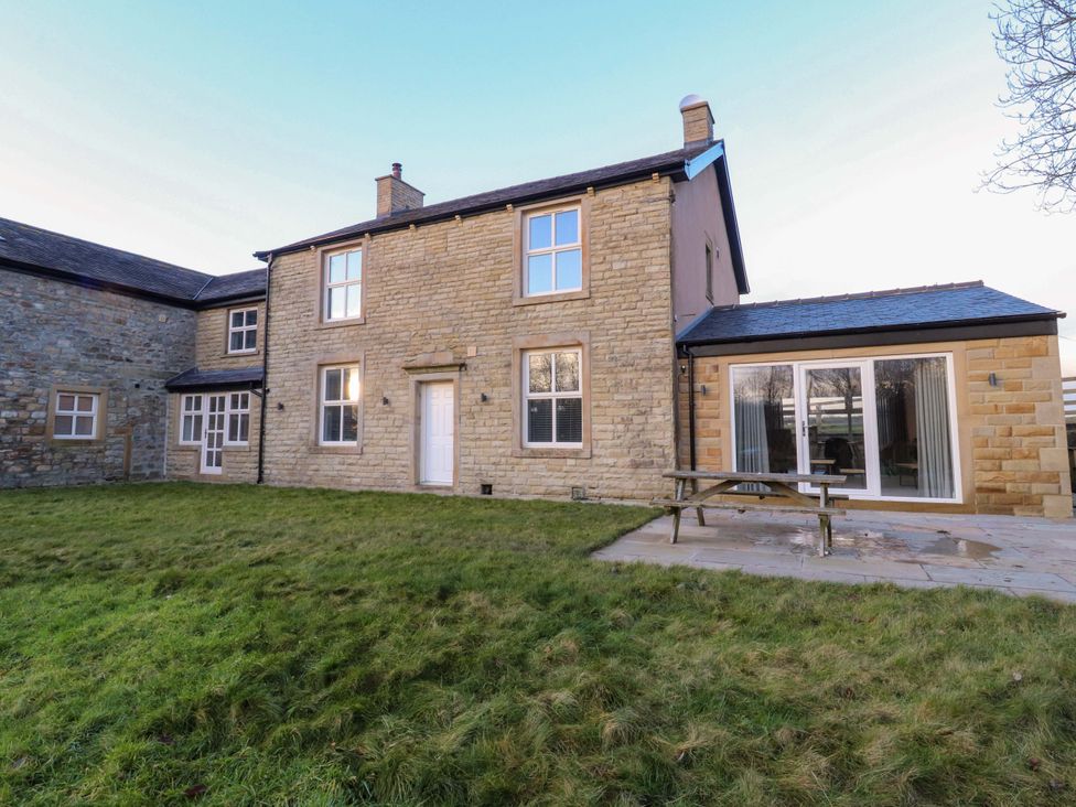 A house with a patio and table outside at The Farm House in Skipton