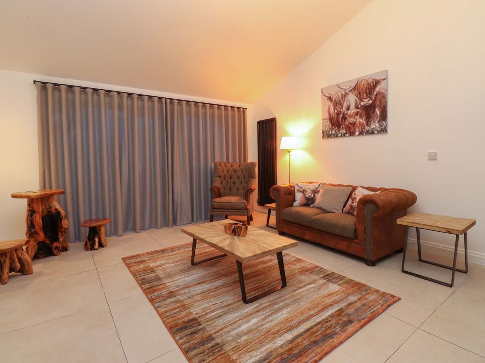 A living room with a sofa and armchair at The Farm House in Skipton