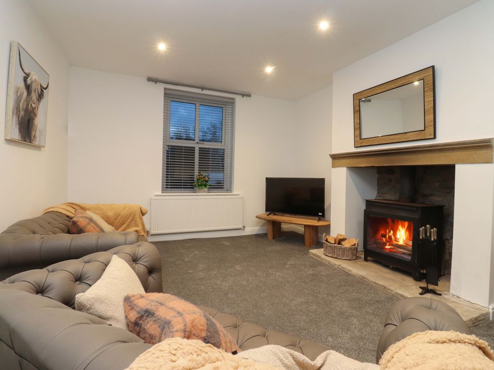 A living room with a fireplace and sofa at The Farm House in Skipton