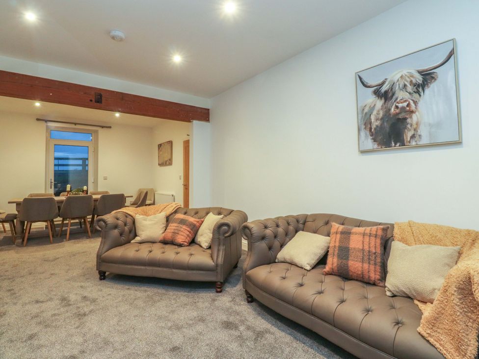 A living room with sofas and a dining area at The Farm House in Skipton