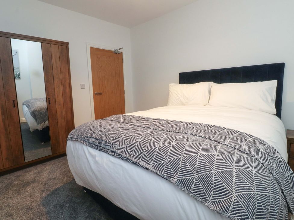 A bedroom with a double bed and a wardrobe at The Farm House in Skipton