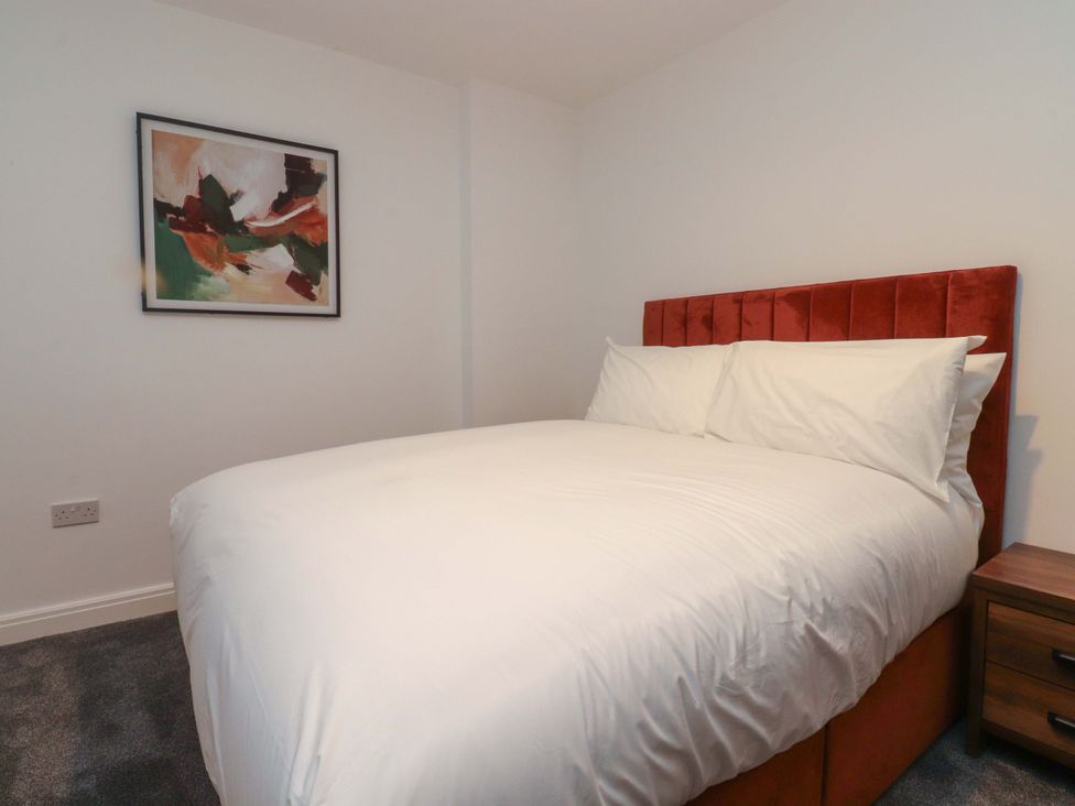 A bedroom with a bed and a painting at The Farm House in Skipton
