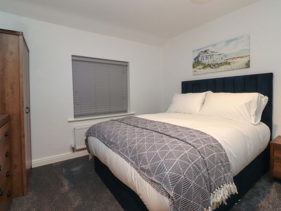 A bedroom with a bed and window at The Farm House in Skipton