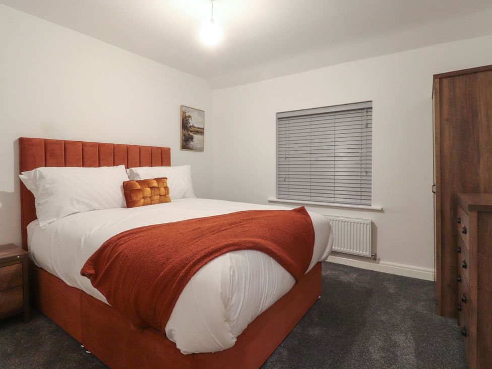 A bedroom with a bed and nightstand at The Farm House in Skipton