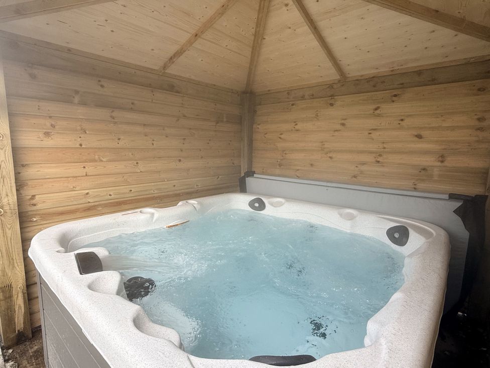 A hot tub in a wooden structure at The Farm House Wigglesworth near Settle