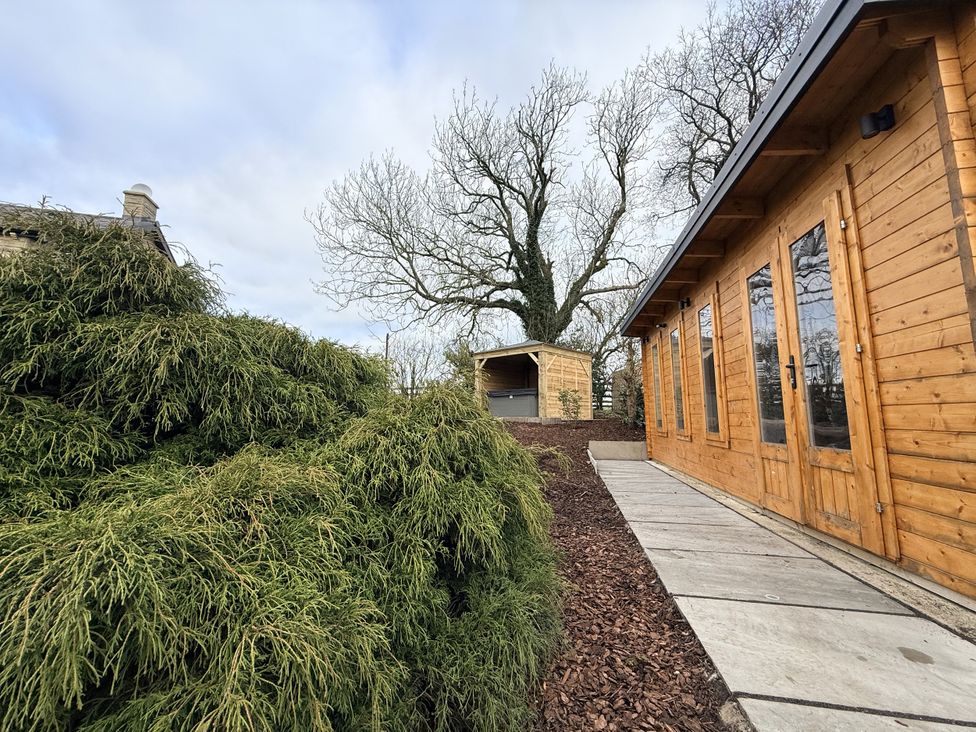 A garden with a wooden shed and a stone pathway at The Farm House in Wigglesworth near Settle