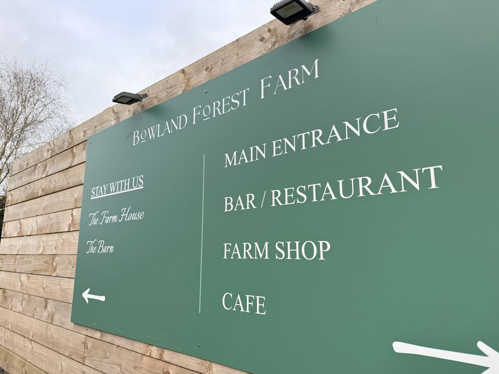 A sign displaying information about Bowland Forest Farm with directional arrows at The Farm House in Wigglesworth near Settle