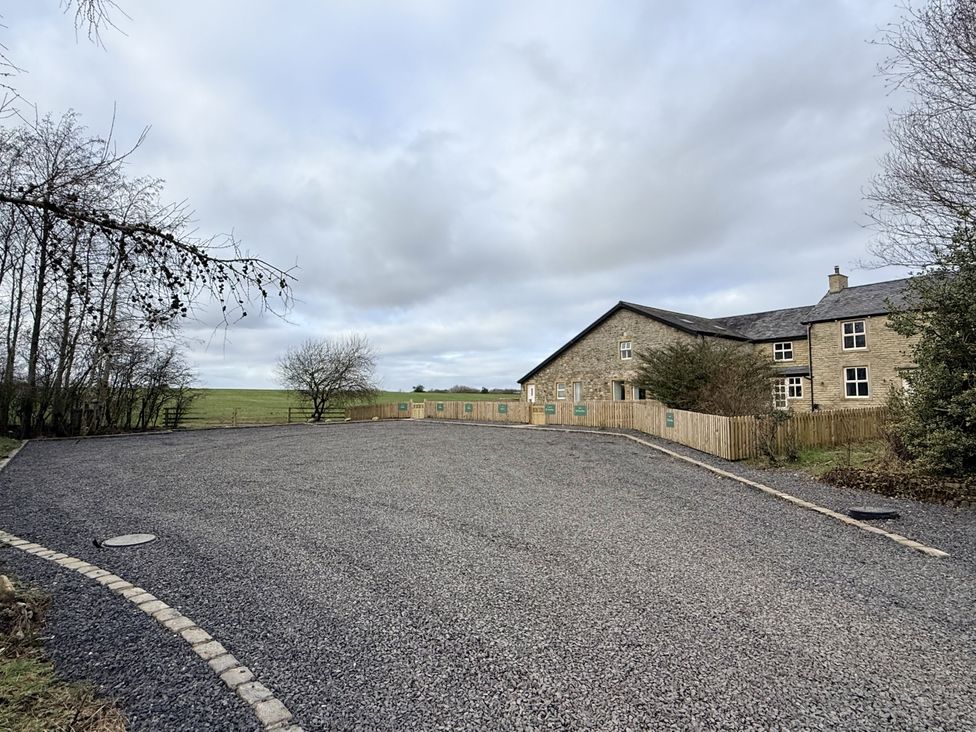 An outdoor area with a gravel driveway and a house at The Farm House in Wigglesworth near Settle