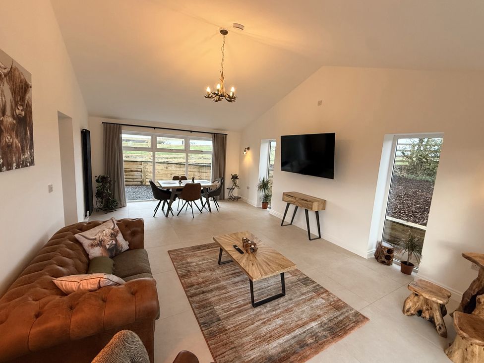 A living room with a sofa and dining table at The Farm House in Wigglesworth near Settle