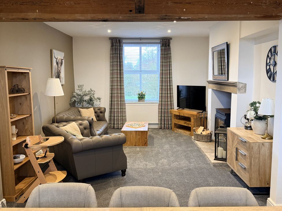 A living room with a sofa, television, and coffee table at The Farm House in Wigglesworth near Settle