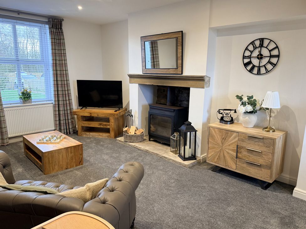 A living room with a sofa, television, and coffee table at The Farm House in Wigglesworth near Settle