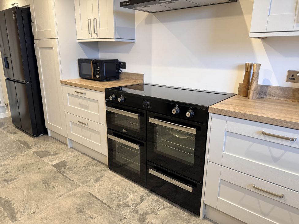 A kitchen with an oven, microwave, and refrigerator at The Farm House in Wigglesworth near Settle