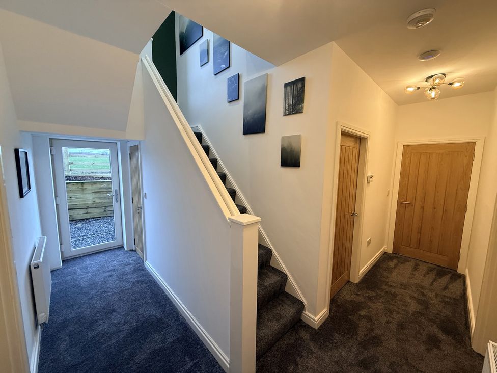A hallway with a staircase and door at The Farm House in Wigglesworth near Settle