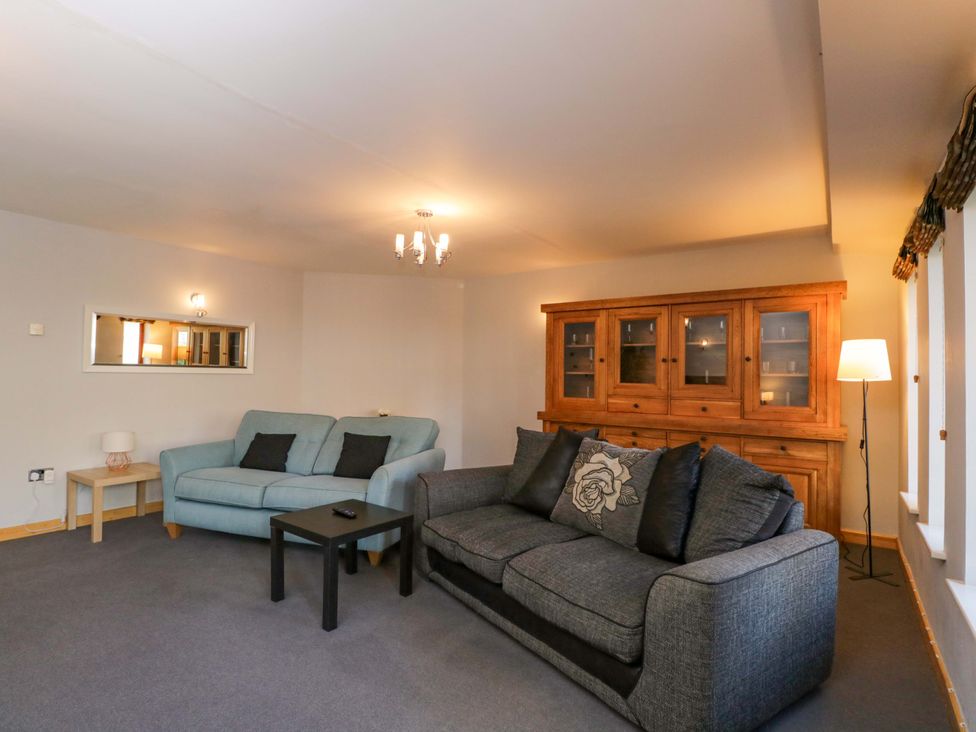 A living room with sofas and a cabinet at Lady Of Lourdes in Whitchurch, Herefordshire