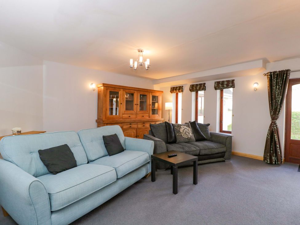 A living room with sofas and a dining cabinet at Lady Of Lourdes Whitchurch, Herefordshire
