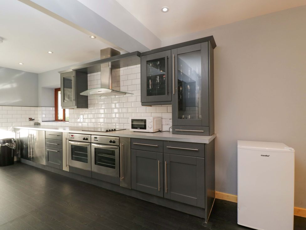 A kitchen with cabinets, stove, microwave, sink, and refrigerator at Lady Of Lourdes in Whitchurch, Herefordshire