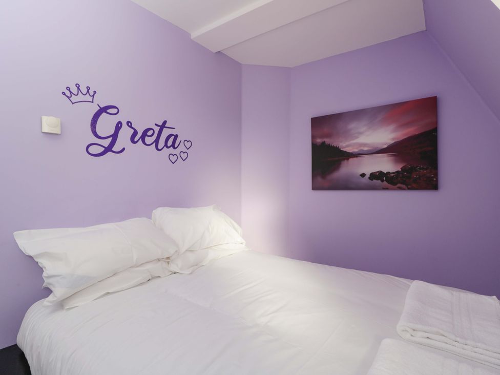 A bedroom with a bed and wall art at Lady Of Lourdes, Whitchurch, Herefordshire