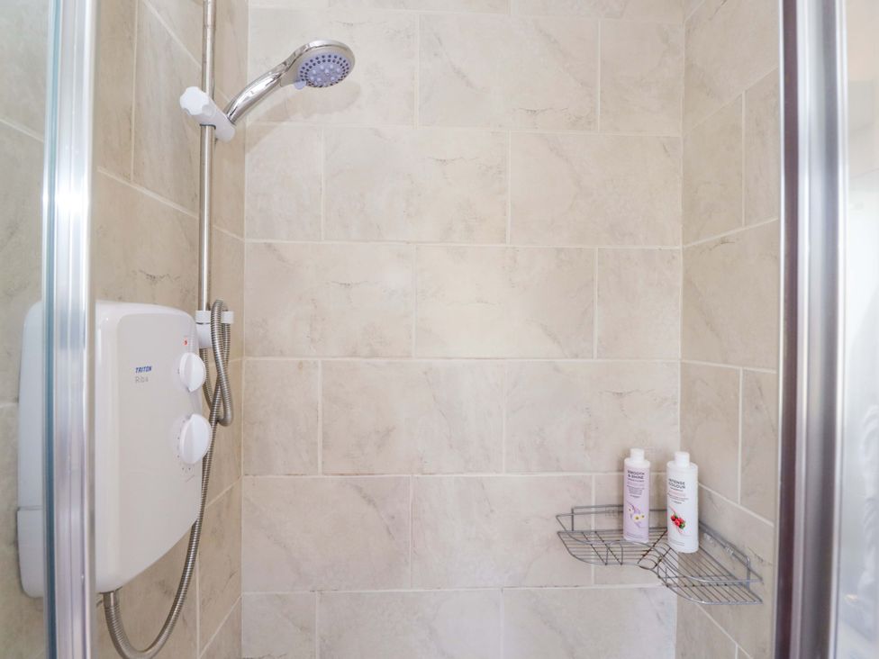 A shower with controls and shampoo on a rack at Lady Of Lourdes in Whitchurch, Herefordshire