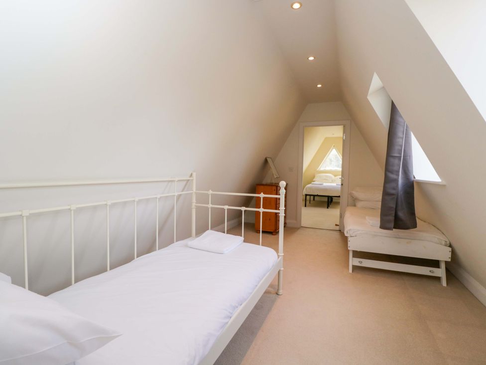 A bedroom with two beds and a nightstand at Lady Of Lourdes in Whitchurch, Herefordshire