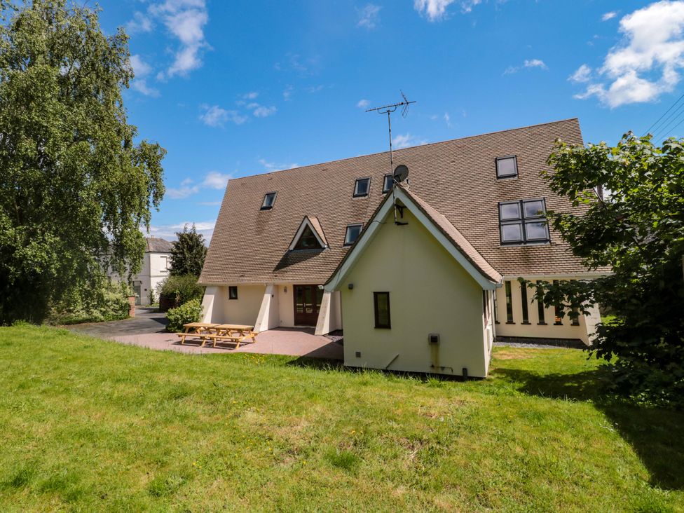 A house with a patio and benches at Lady Of Lourdes in Whitchurch, Herefordshire