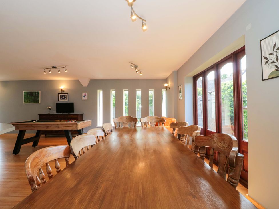 A dining room with a long table and chairs at Lady Of Lourdes in Whitchurch, Herefordshire