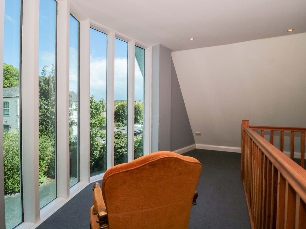 A landing with large windows and a chair at Lady Of Lourdes in Whitchurch, Herefordshire