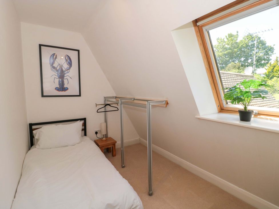 A bedroom with a bed and hanging rail at Lady Of Lourdes in Whitchurch, Herefordshire