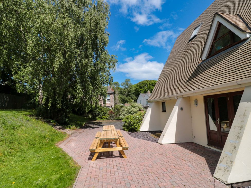 A garden with a wooden bench and pathway at Lady Of Lourdes in Whitchurch, Herefordshire