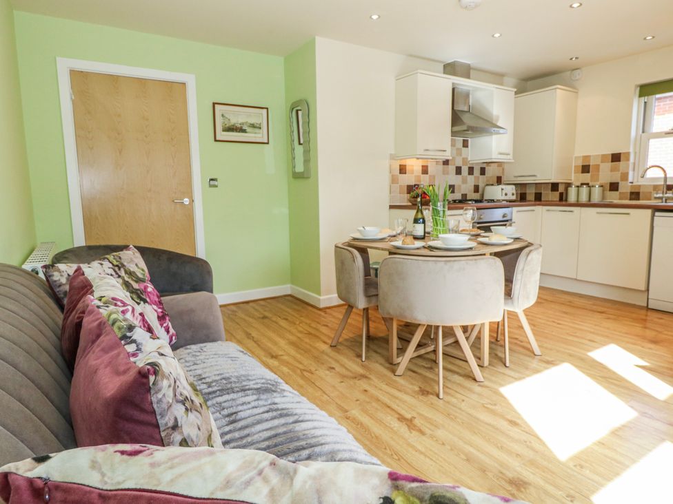 A kitchen area with a dining table and chairs at Rodwell Holt in Weymouth