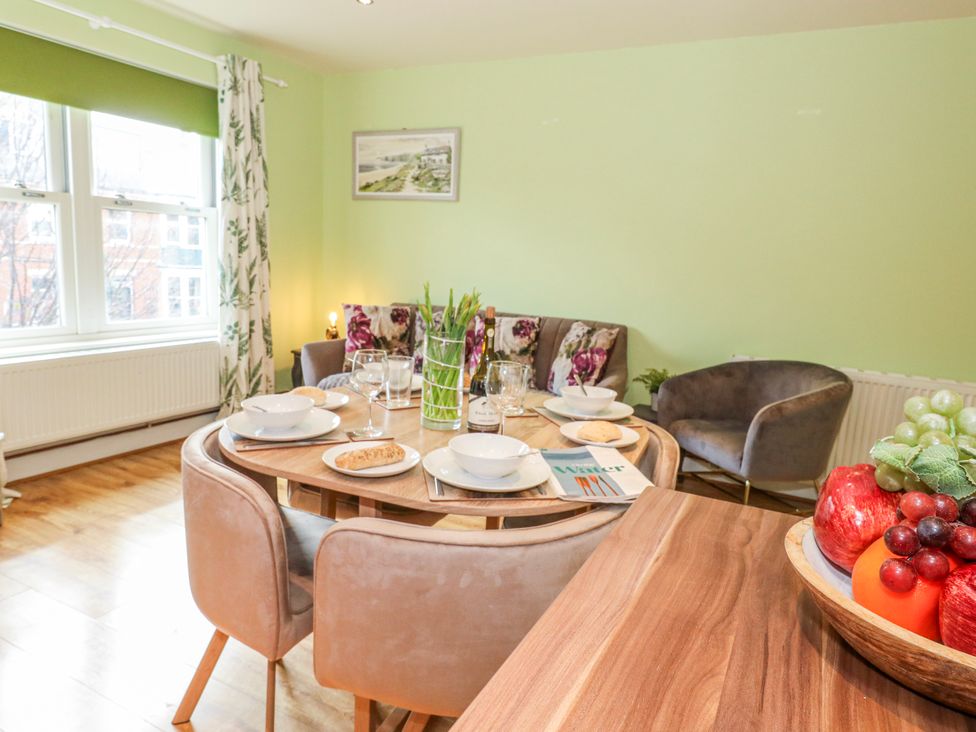 A dining room with a round table set for dining at Rodwell Holt in Weymouth