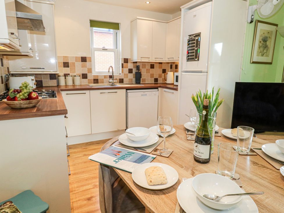 A kitchen with a table set for dining at Rodwell Holt in Weymouth