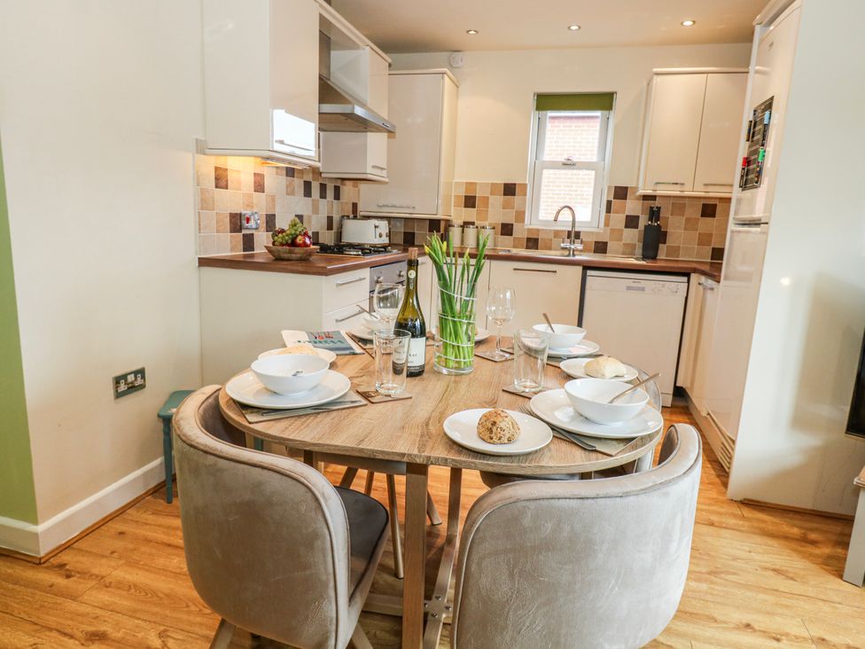 A kitchen with a dining table and chairs at Rodwell Holt in Weymouth
