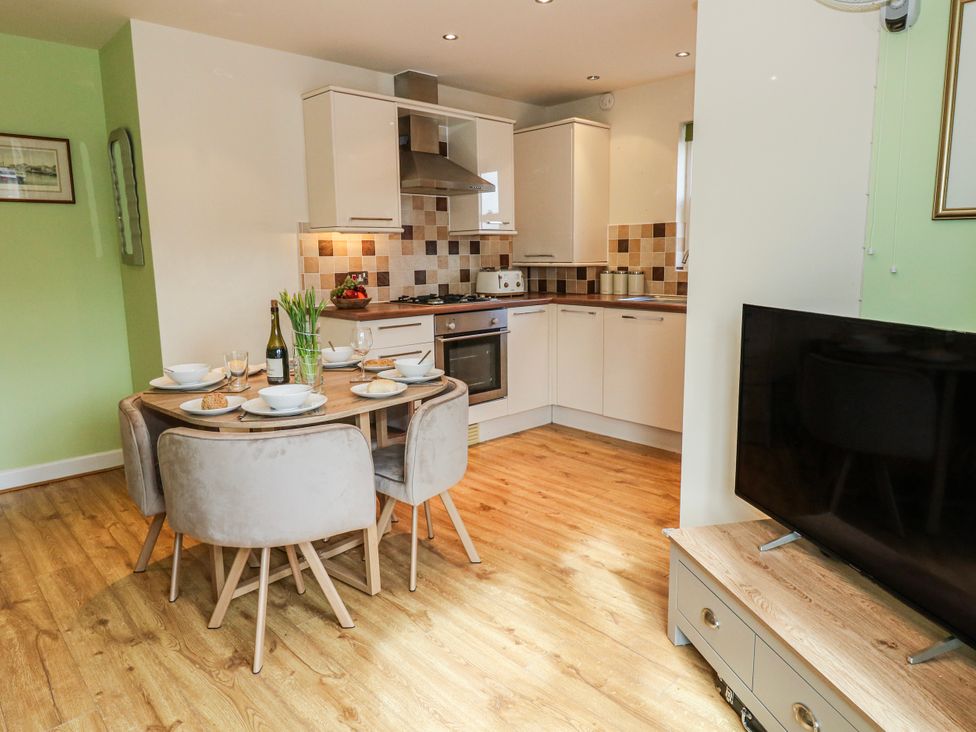 A dining room with a table set for meals at Rodwell Holt in Weymouth