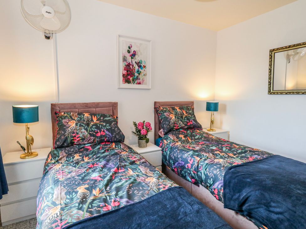 A bedroom with two beds and a flower vase at Rodwell Holt in Weymouth